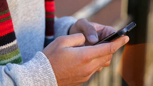 istock Young Hands Typing On A Mobile Telephone Outdoors 535433809