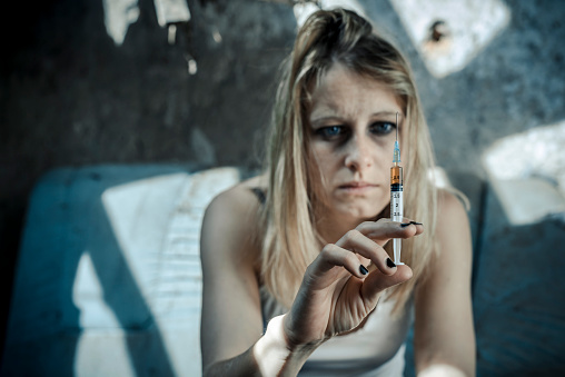 Woman doing heroin injection. Drug addiction concept. 