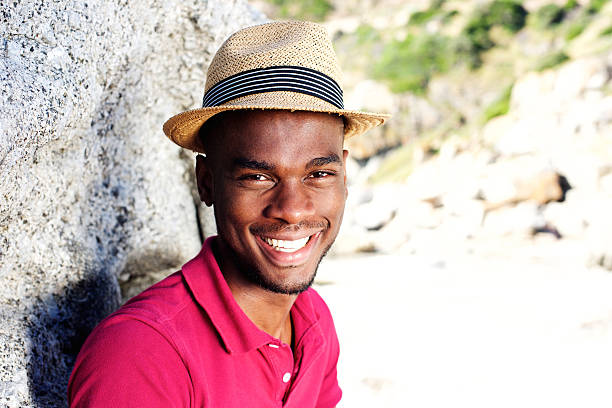 istock Handsome young man with hat smiling at the beach 535442318