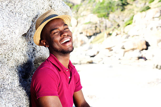 istock Happy young guy in hat smiling at the beach 535442766