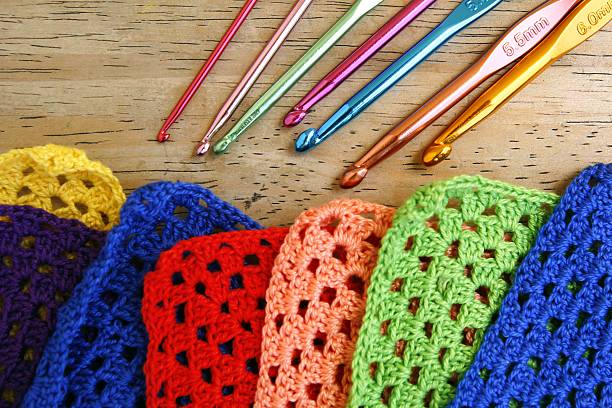 Colorful crochet hooks and granny squares stock photo