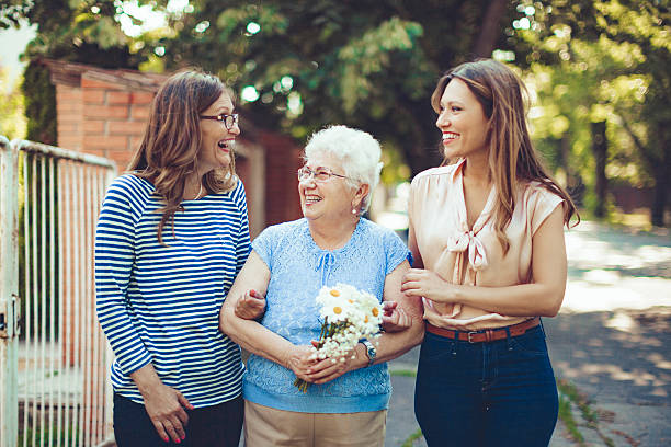 Together is happier Laughing senior woman is walking down the street with her daughter and granddaughter hispanic grandmother stock pictures, royalty-free photos & images