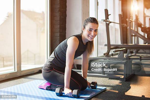 Mujer Joven Haciendo Ejercicios Con Pesas En El Gimnasio Foto de stock y más banco de imágenes de Actividad