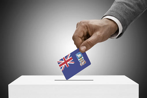 Black male holding flag. Voting concept - Falkland Islands