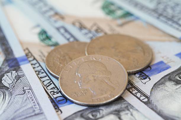 istock Macro shot of quarters on one hundred dollar bills 535451474