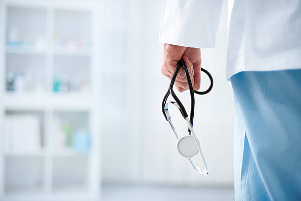 Doctor with stethoscope in a hospital Doctor with stethoscope in a hospital, back view lab coat photos stock pictures, royalty-free photos & images