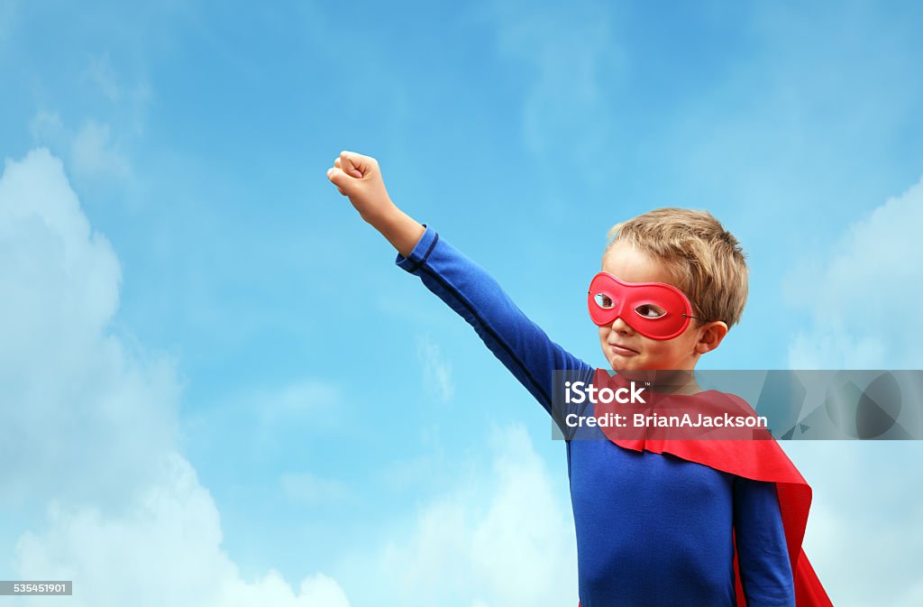 Boy in red superhero cape and mask Superhero child concept for childhood, imagination and aspirations Superhero Stock Photo