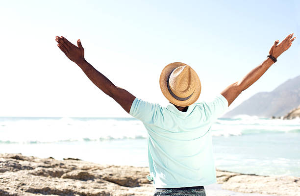 istock Man standing at beach with his hands wide open 535452978