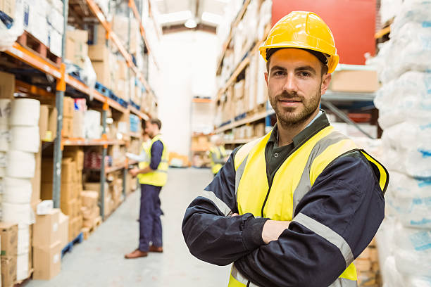 istock Smiling worker wearing yellow vest with arms crossed 535454941