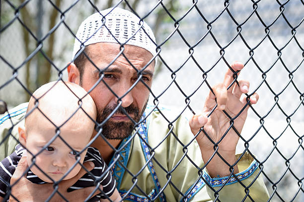 istock Muslim refugee holding his baby 535455398