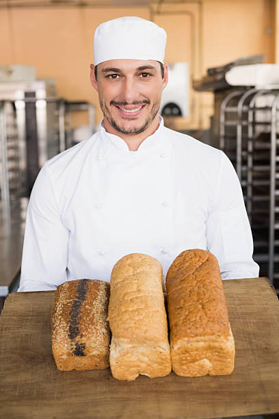 istock Smiling baker showing loaves of bread 535455879