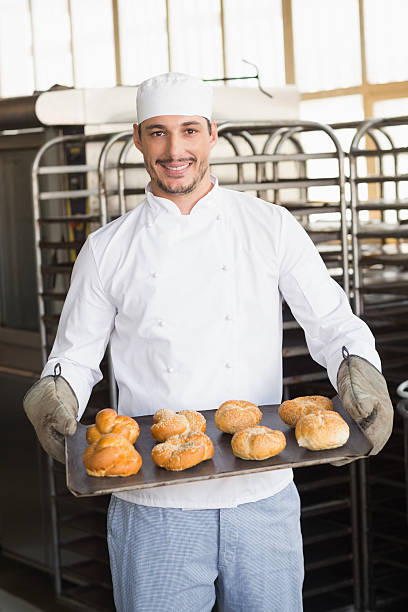 istock Baker showing tray of rolls 535455939