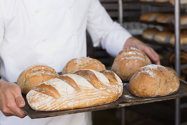 istock Baker holding tray of bread 535456017