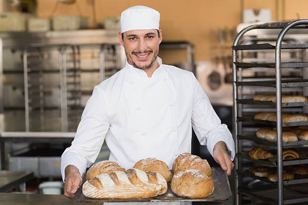 istock Baker holding tray of bread 535456023