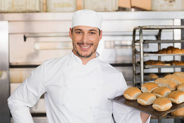istock Happy baker showing tray of fresh bread 535456143