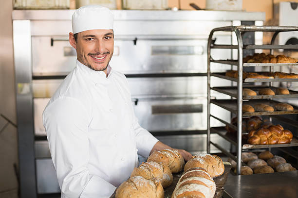 istock Happy baker showing tray of fresh bread 535456153
