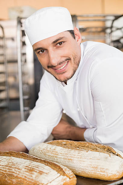 istock Happy baker holding tray of fresh bread 535456243