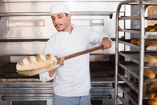 istock Happy baker taking out fresh loaf 535456339