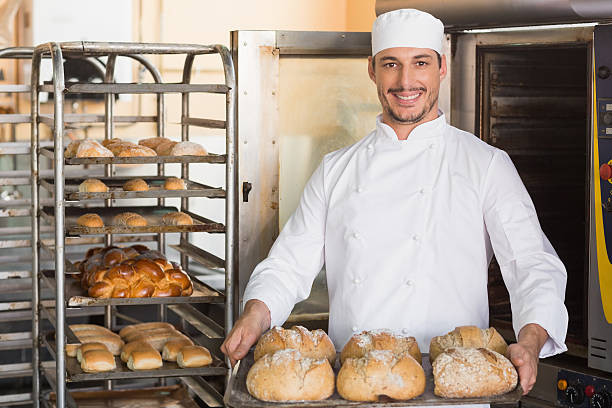 istock Happy baker showing tray of fresh bread 535456565