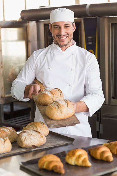 istock Happy baker showing tray of fresh bread 535456581