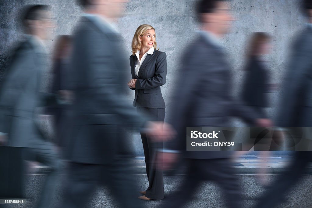 Businesswoman Turns Head To Look In Direction Pedestrians Are Walking A very concerned businesswoman stops and looks behind her as she expresses concern over the fact that she might be going in the wrong direction. Mistake Stock Photo
