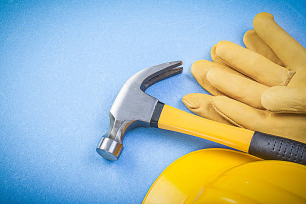 istock Claw hammer protective gloves building helmet on blue background 535459226