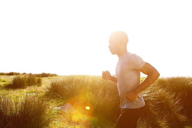 ヘルシーな若いアフリカ人男性ランニングビーチで - running jogging african descent nature ストックフォトと画像