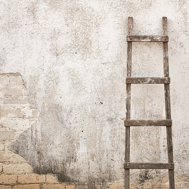 istock weathered stucco wall with wooden ladder 535462108