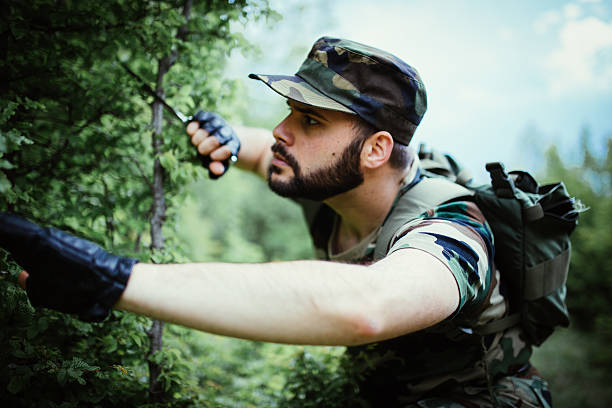 istock Young soldier with knife in forest 535462370