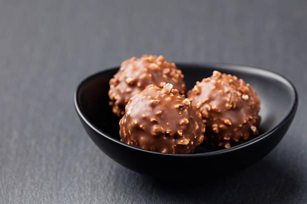 istock Chocolate candies, truffle in ceramic black bowl Grey slate background 535462492
