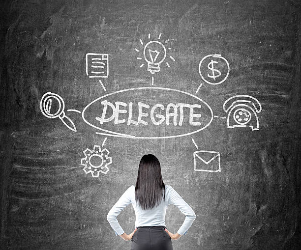 Delegating sketch Businesswoman looking at delegating sketch on chalkboard delegating stock pictures, royalty-free photos & images