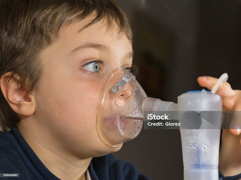 child with electric nebulizer kid with mask for inhalations 2015 Stock Photo