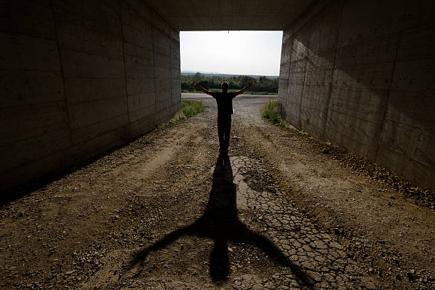 istock Man with arms outstretched at large concrete building passage 535463406