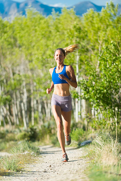 Women Trail Runner Running In The Trees 
