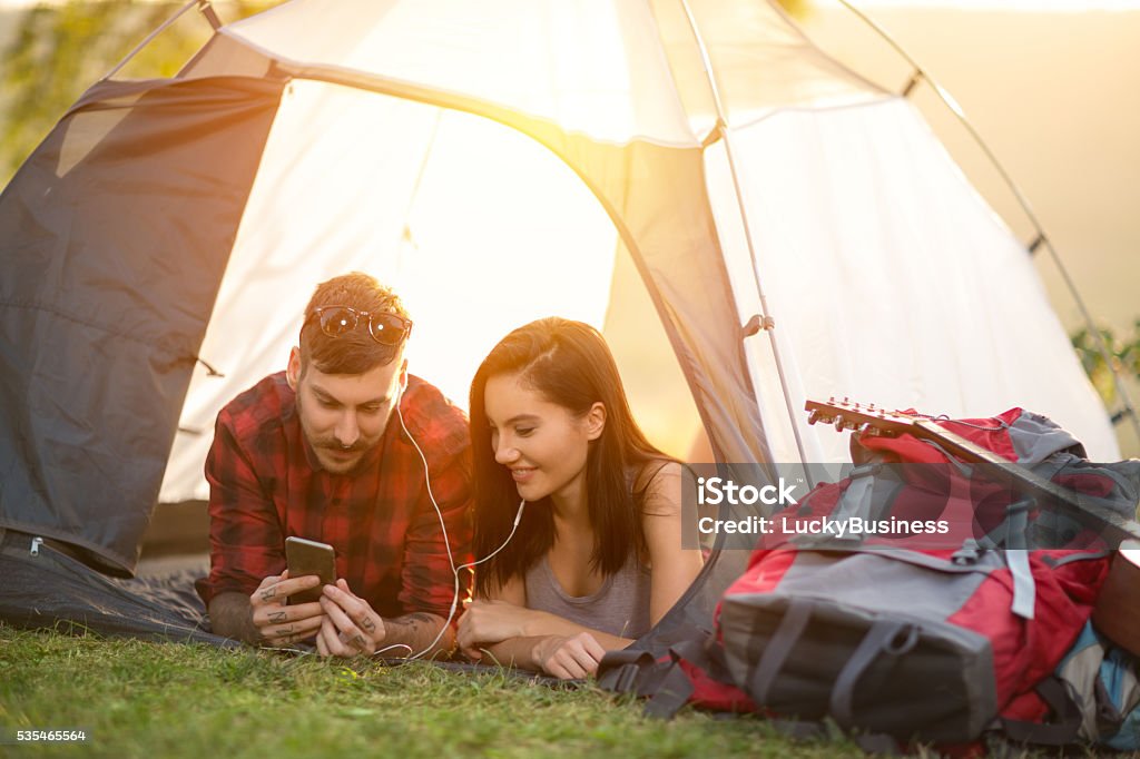 Camping couple in tent taking selfie using smartphone Camping hipster couple in tent taking selfie using smartphone Arts Culture and Entertainment Stock Photo