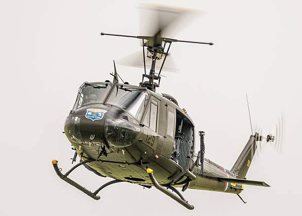 Bell UH-1H - Vietnam veteran Huey / Iroquois Duxford, UK - May 28, 2016: a Bell UH-1H Huey / Iroquois military helicopter used by the US Army during the Vietnam War pictured in flight over Cambridgeshire, England.  uh 1 helicopter stock pictures, royalty-free photos & images