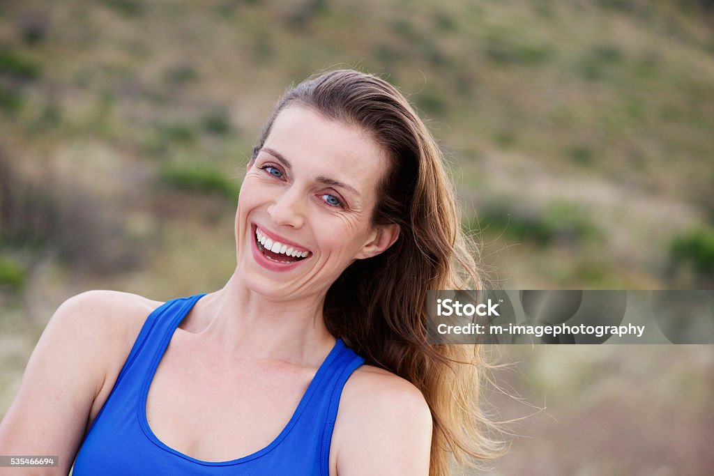 Older woman laughing outside in park Portrait of older woman laughing outside in park 30-39 Years Stock Photo