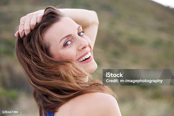 Foto de Saudável Mais Mulher Sorridente Ao Ar Livre Com A Mão No Cabelo e mais fotos de stock de 30 Anos