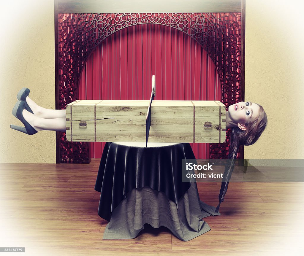 Magician sawing a woman Magician sawing a woman with a saw.Photo combination concept Magician Stock Photo