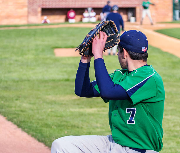 Left Handed Baseball Pitcher Warming Up A left-handed16 year old high school baseball team pitcher winding up to deliver a strike. He is warming up before the game starts by throwing practice pitches along the sideline. high school baseball stock pictures, royalty-free photos & images