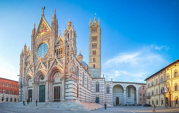 Famous Piazza del Duomo with historic Siena Cathedral, Tuscany, Italy Beautiful panoramic view of famous Piazza del Duomo with historic Siena Cathedral at sunset, Tuscany, Italy basilica santa claus town square italy stock pictures, royalty-free photos & images