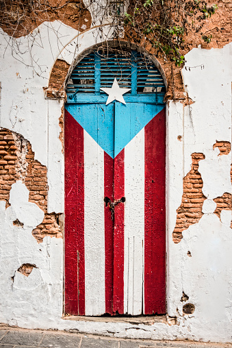 Bandera puertorriqueña en abandonado edificio puerta. photo