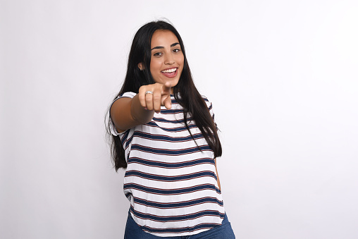 Young beautiful woman pointing to camera. Isolated white background.