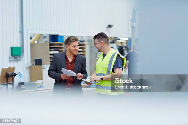 Two Colleagues Talking To One Another At Factory Stock Photo - Download Image Now - Audit, Engineer, Manager