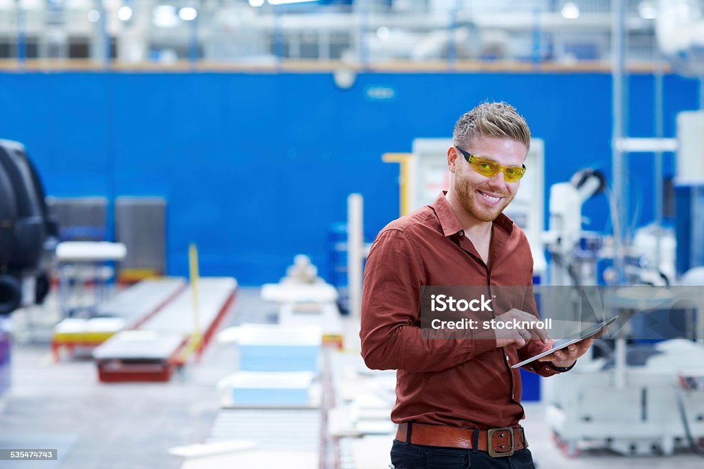 Junger Mann auf der Verkaufsfläche entgegennehmen mit digitalen tablet Fabrik - Lizenzfrei 2015 Stock-Foto