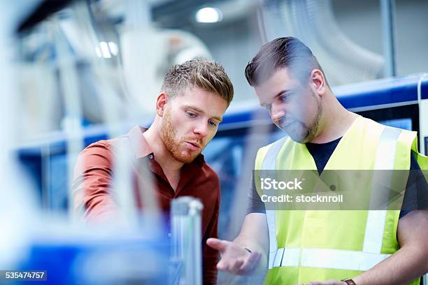 Young Men Working In Manufacturing Facility Stock Photo - Download Image Now - Engineer, Advice, Industry