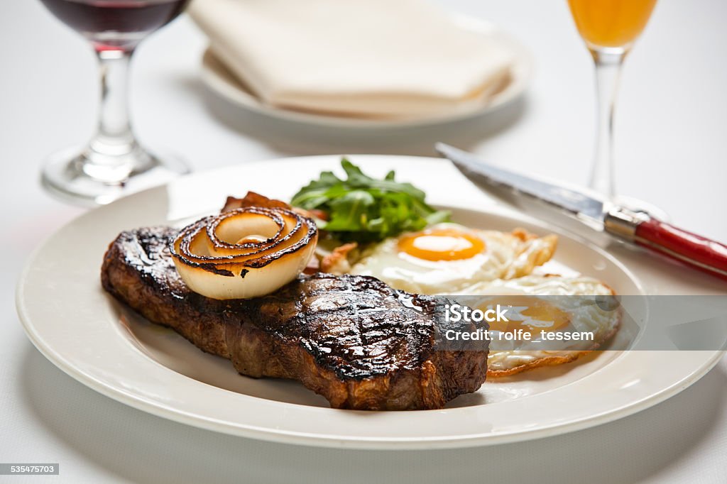 Steak and Eggs Steak and eggs on white table cloth Egg - Food Stock Photo