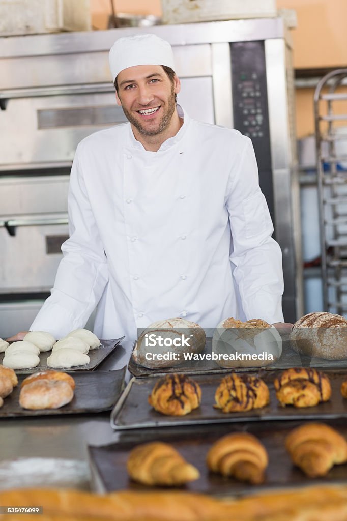 Smiling baker looking at camera Smiling baker looking at camera in the kitchen of the bakery Baker - Occupation Stock Photo