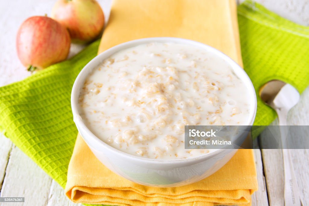 Oatmeal porridge Oatmeal fresh hot simple porridge with spoon on napkin and wooden table. Natural healthy vegetarian breakfast, close up, horizontal. 2015 Stock Photo