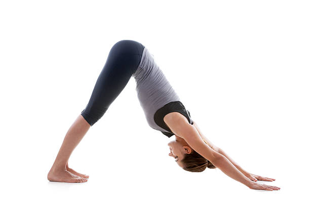 Pose urdhva mukha shvanasana Sporty yoga girl on white background stretching in pose Adho Mukha Svanasana (downward-facing dog Pose, downward dog, down dog) downward facing dog position stock pictures, royalty-free photos & images